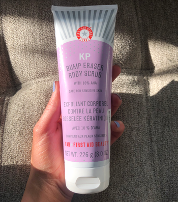 reviewer holding tube of the body scrub