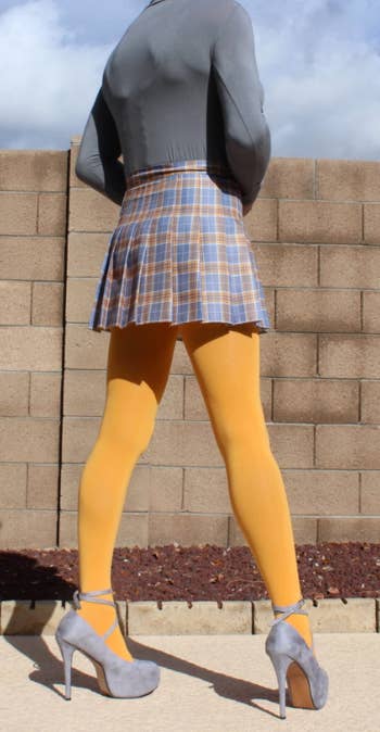 reviewer in short skirt with yellow opaque tights