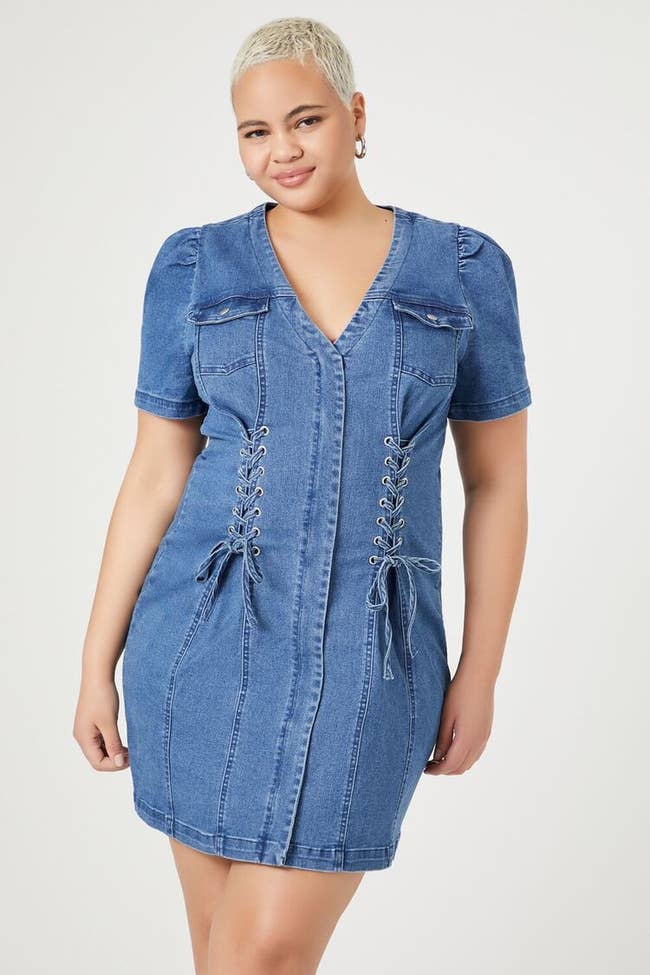 model in blue denim short sleeve mini dress with lace up ties on either side
