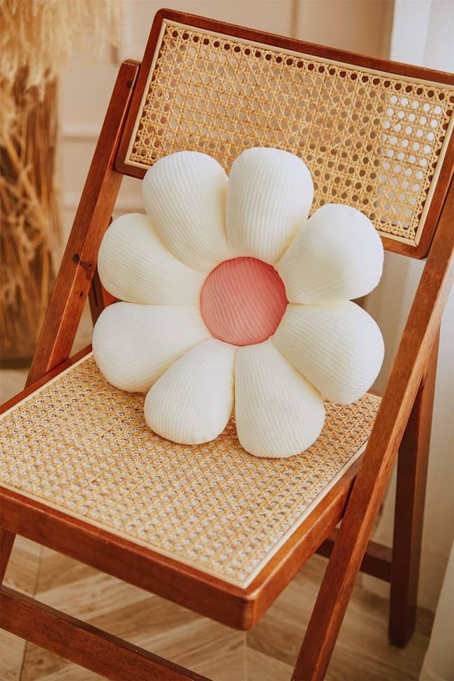 flower shaped pillow on a woven chair