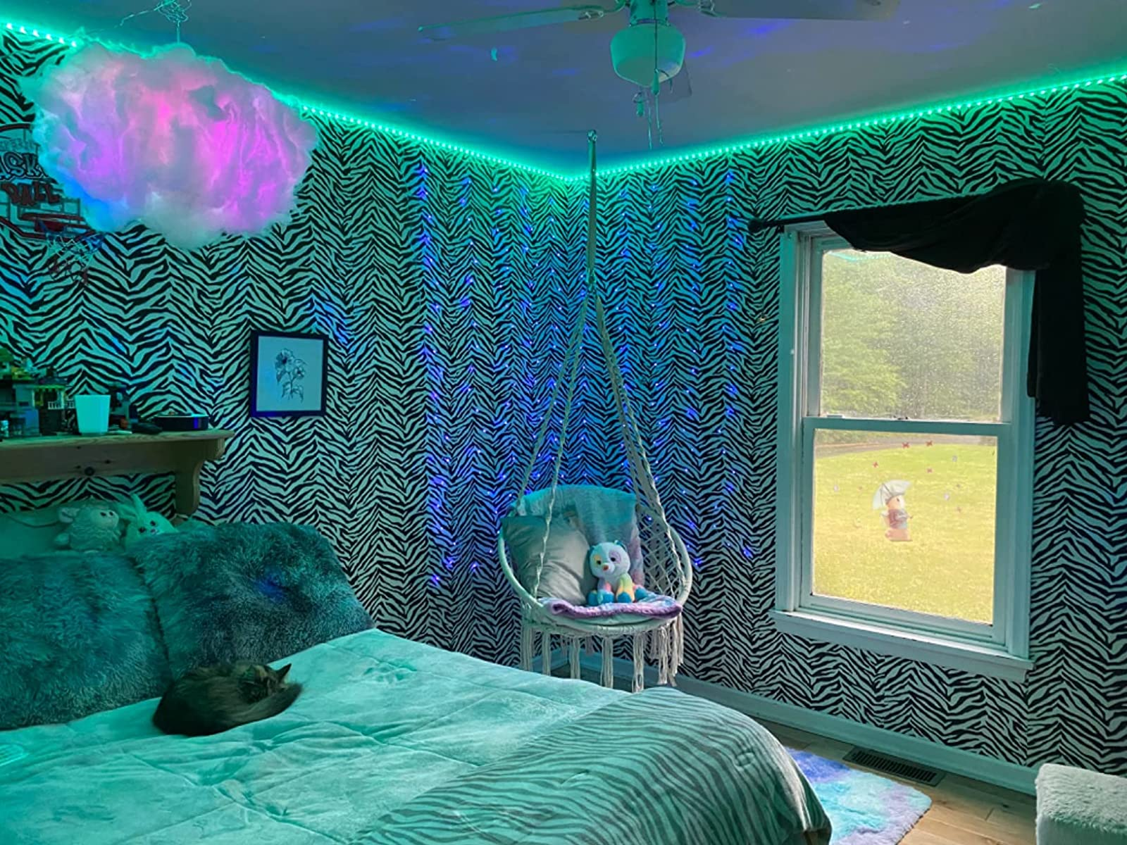 A reviewer's room with the blue and purple lit up cloud floating above their bed
