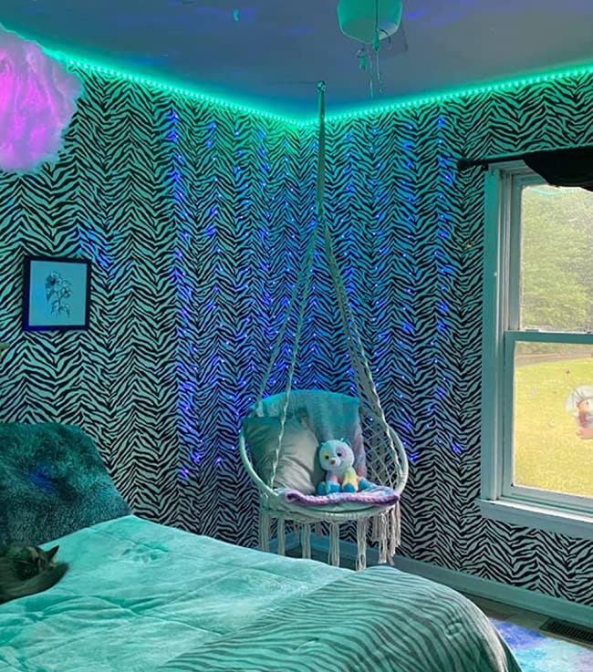 A reviewer's room with the blue and purple lit up cloud floating above their bed