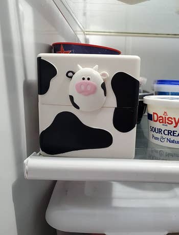 A squared shaped closed small storage box shaped like a cow 
