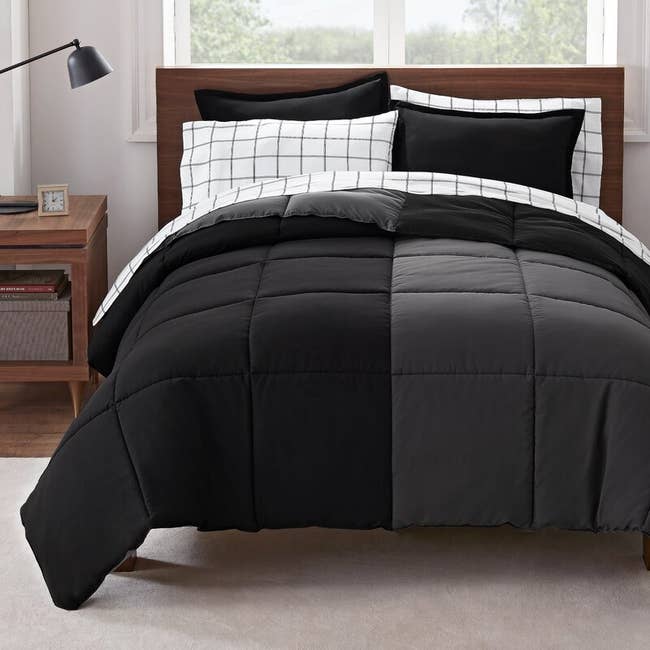 A black and grey bed-in-a-bag on a bed