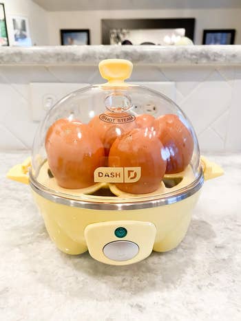 reviewer's yellow egg cooker with eggs