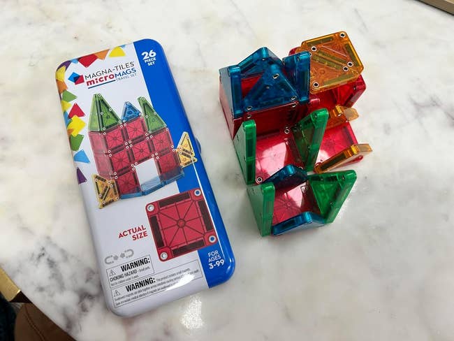A acceptable   of colorful magnetic gathering  tiles and packaging connected  a marble surface, suitable for ages 3-99, includes 26 pieces for originative  play