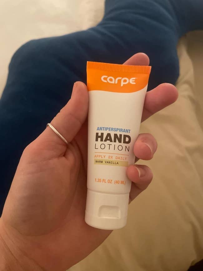 Person holding a tube of Carpe Antiperspirant Hand Lotion