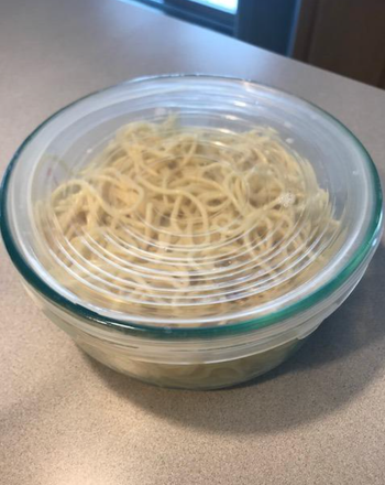 Transparent lid stretched over a bowl of noodles 