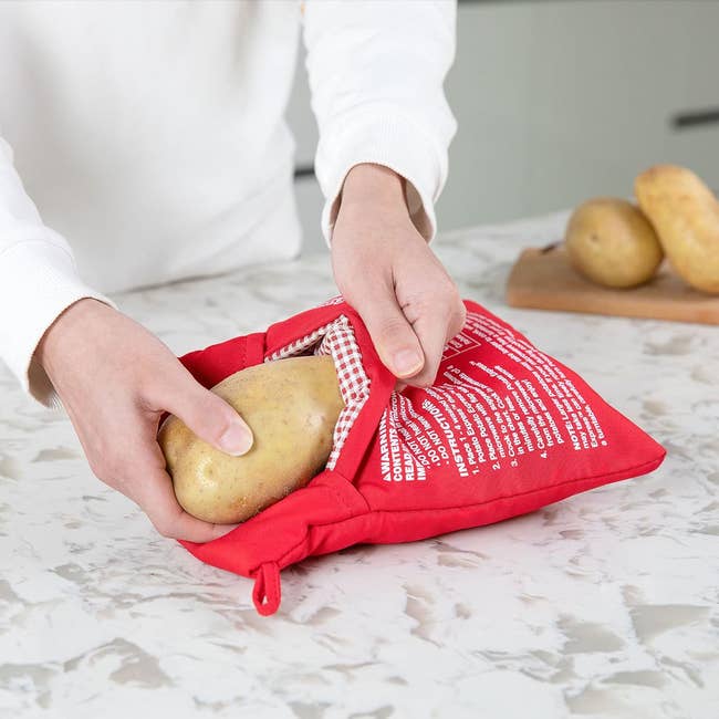 model slipping a potato into the microwave cooker bag