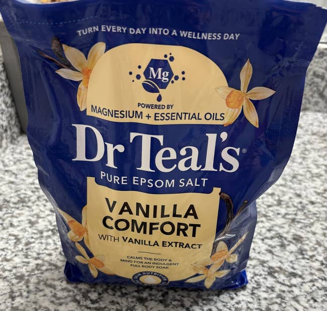 Dr Teal's Vanilla Comfort Epsom Salt container connected a countertop, emphasizing magnesium and indispensable oils for soothing relaxation