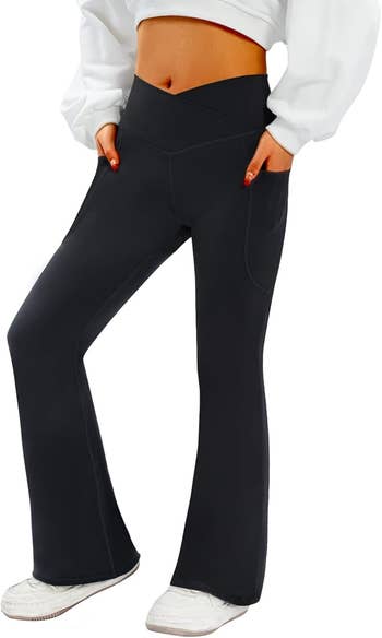 Person wearing high-waisted, wide-leg yoga pants with pockets and a cropped sweater, showcasing comfortable, casual fashion