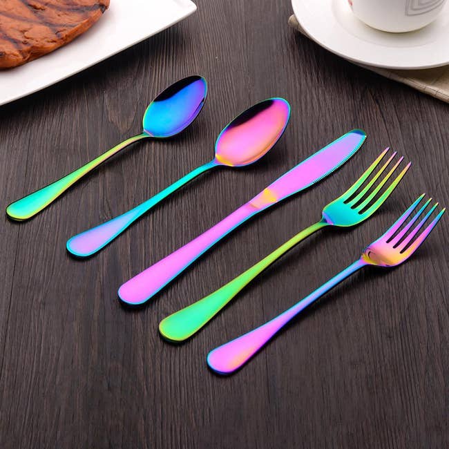 two spoons, a knife, and two forks on a table 