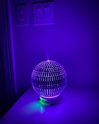 The diffuser glowing purple and emitting diffused essential oils