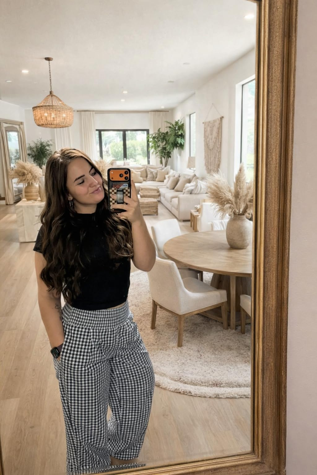 Person taking a reflector  selfie successful  a stylish, modern   surviving  country   with neutral decor and checkerboard signifier   pants