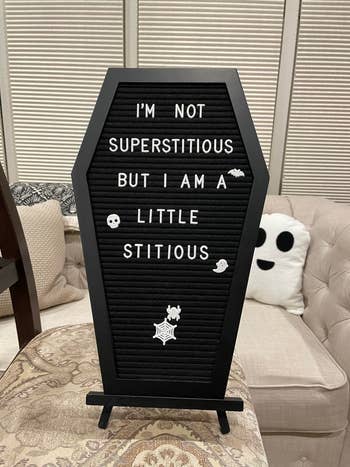 Coffin-shaped letter board on a chair reads: 