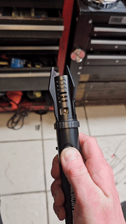 Hand holding a butane torch successful a store setting, demonstrating its adjustable flame