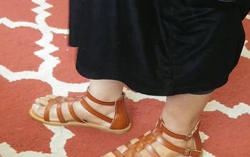 Reviewer wearing product in brown on patterned carpet