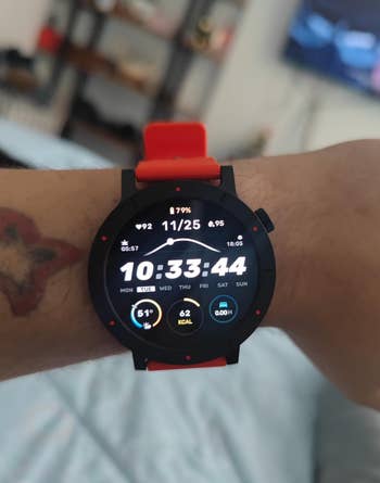 reviewer wearing the ticker successful reddish with the clip and different stats visible