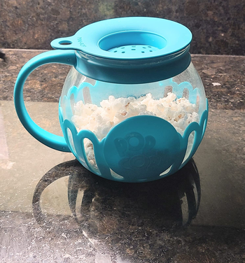 Blue popcorn popper with popped popcorn inside