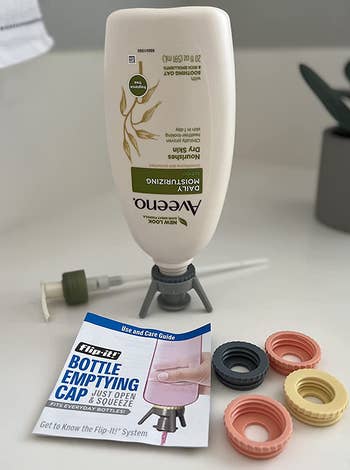 reviewer photo of a moisturizer bottle being propped upside down with one of the bottle emptying caps, with the rest of the kit laid out in front