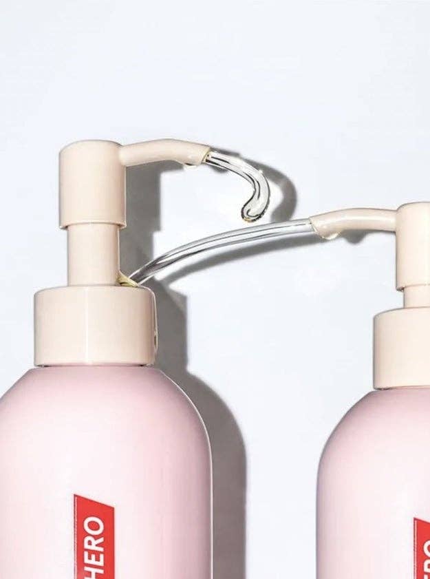 Two bottles with pump dispensers and a reddish  label, apt  quality   oregon  skincare products, positioned against a minimalistic background