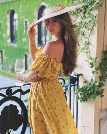 Reviewer in a yellow off the shoulder puff sleeve floral midi dress 
