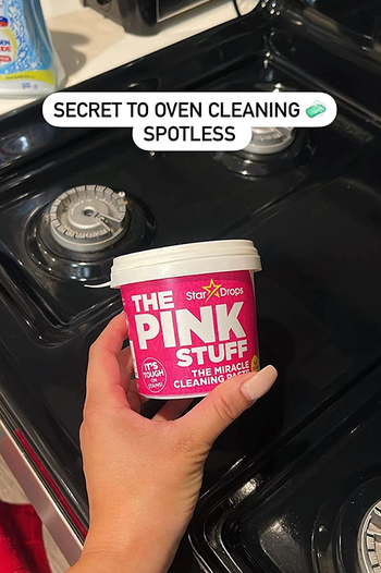 reviewer holding container of the pink stuff