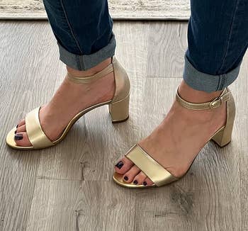 reviewer wearing the gold heels