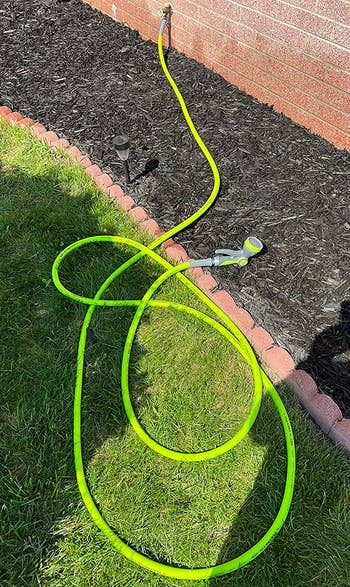 a reviewer photo of the hose splayed out on a lawn 
