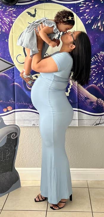 a reviewer wearing the fitted dress in light blue