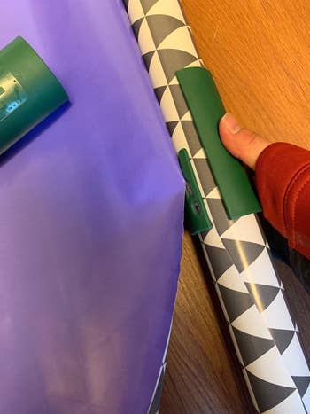 reviewer using tool to cut gift wrap