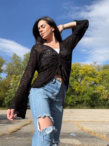 reviewer wearing the black crocheted top