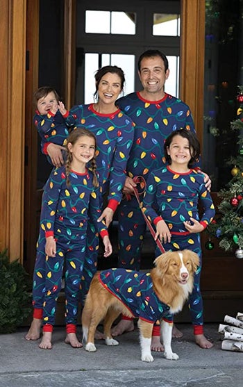 a family in blue pajamas with holiday lights on them