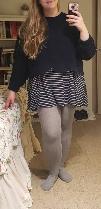 reviewer wearing a skirt with the ribbed sweater tights