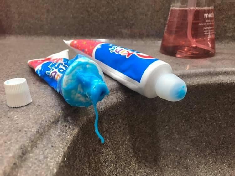 A messy tube of toothpaste next to one that has the mess-free cap 
