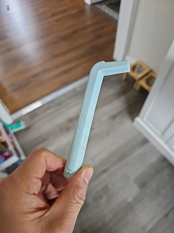 reviewer holding the light blue HiccAway