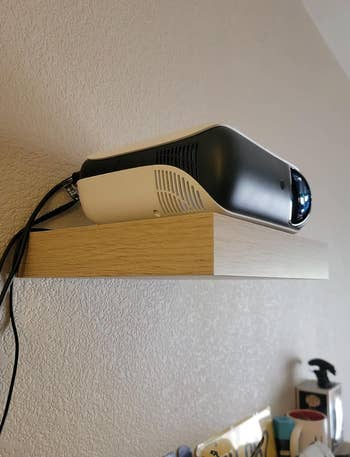 Projector mounted on wall shelf 