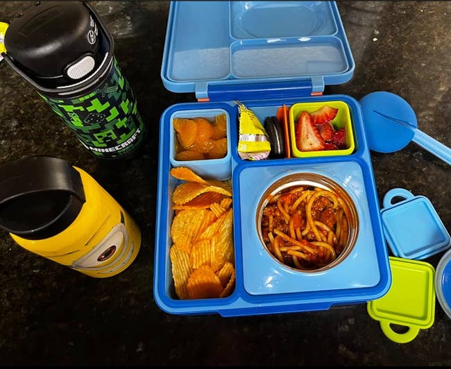 reviewer's blue Omiebox with food in the different compartments