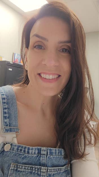 Reviewer successful denim overalls smiling indoors, showing disconnected hair