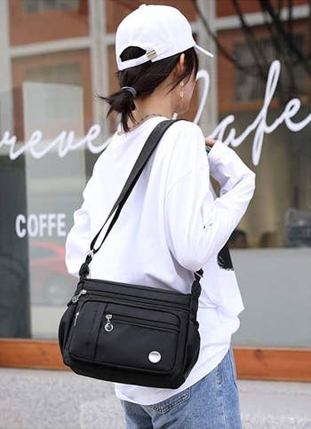 a model wearing the shoulder bag in black 