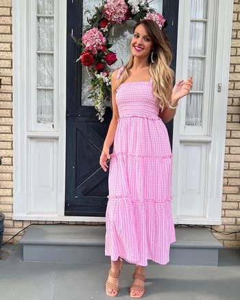 reviewer posing wearing tiered pink dress and shoes in tan