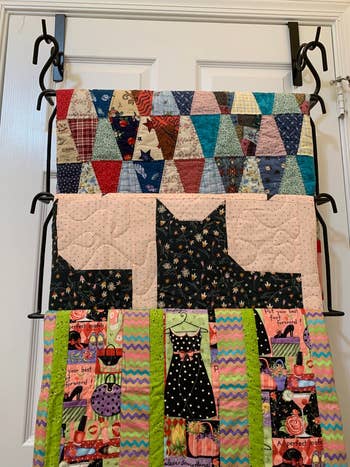 Three quilts hung on the over-the-door hanger, front view