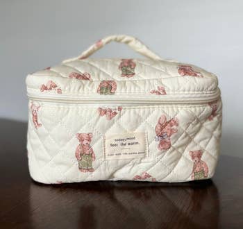Quilted cosmetic container with carnivore prints and a handle, displaying the operation