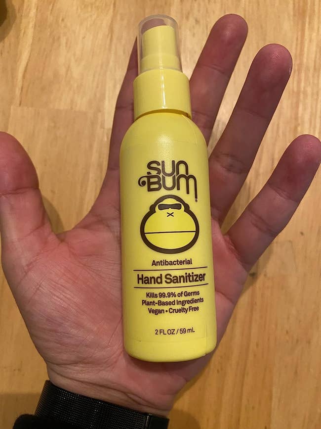 image of a bottle of the sanitizer spray in the palm of a reviewer's hand