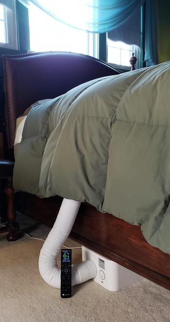 reviewer photo of the bed fan peeking out under a comforter