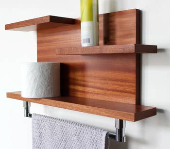 Product in dark brown wood  with silver metal towel bar attached to a white wall