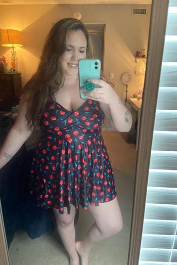 a reviewer wearing the cherry print swim dress
