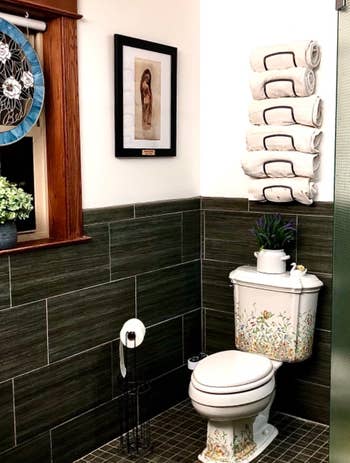 Reviewer's black mounted towel rack above toilet 