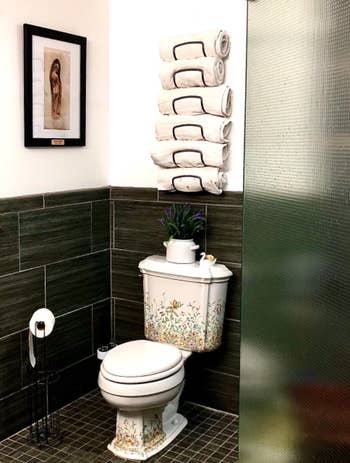 Reviewer's black mounted towel rack above toilet 