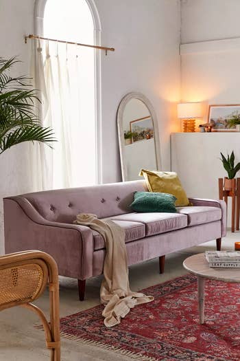 the pink couch set up in a living room